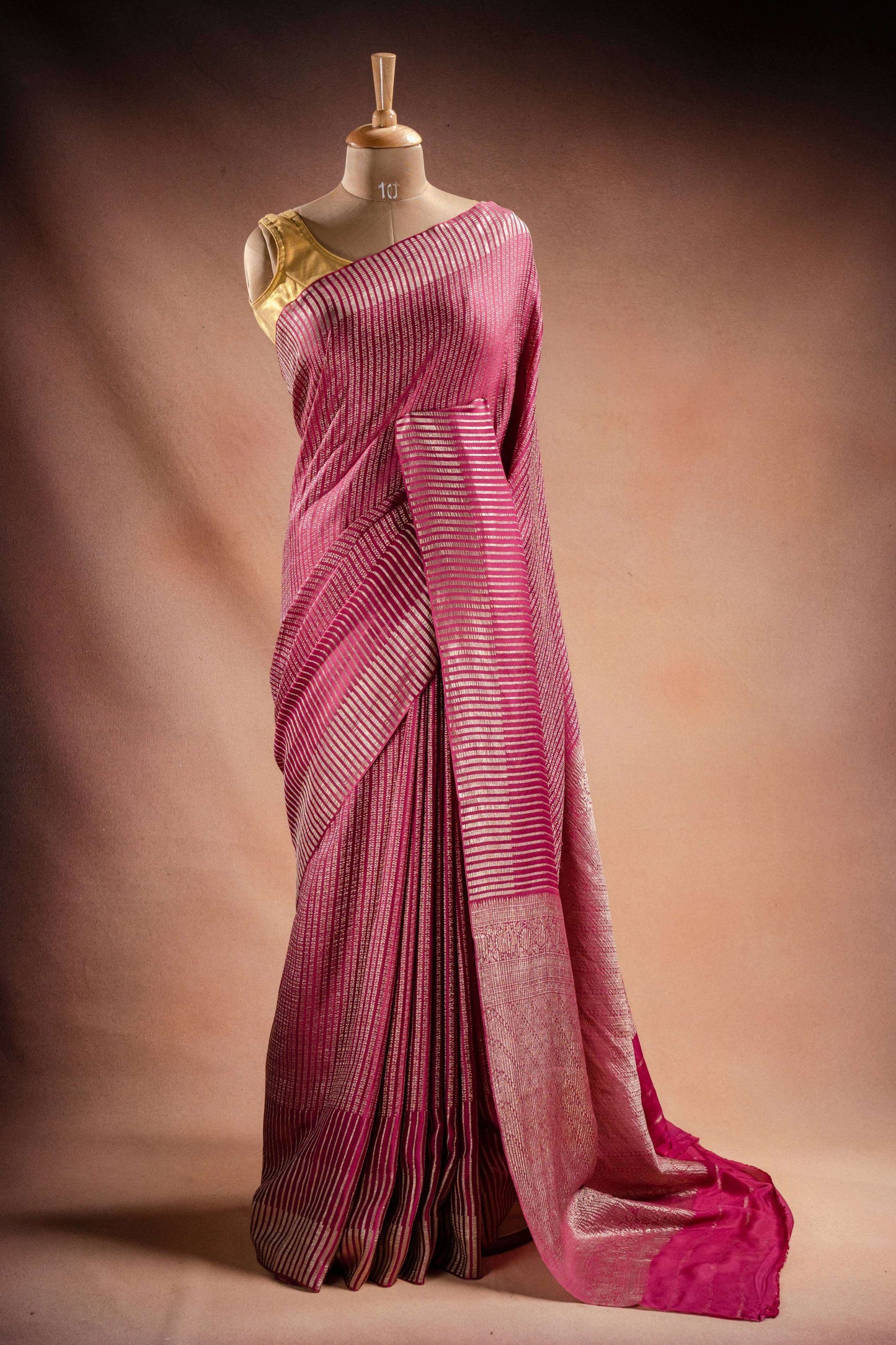 Pink Crepe Silk Saree with Zari Stripes draped elegantly on a mannequin showcasing its intricate zari stripes.